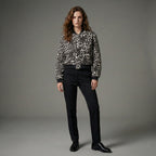 Person wearing a leopard print shirt and black pants on a gray background