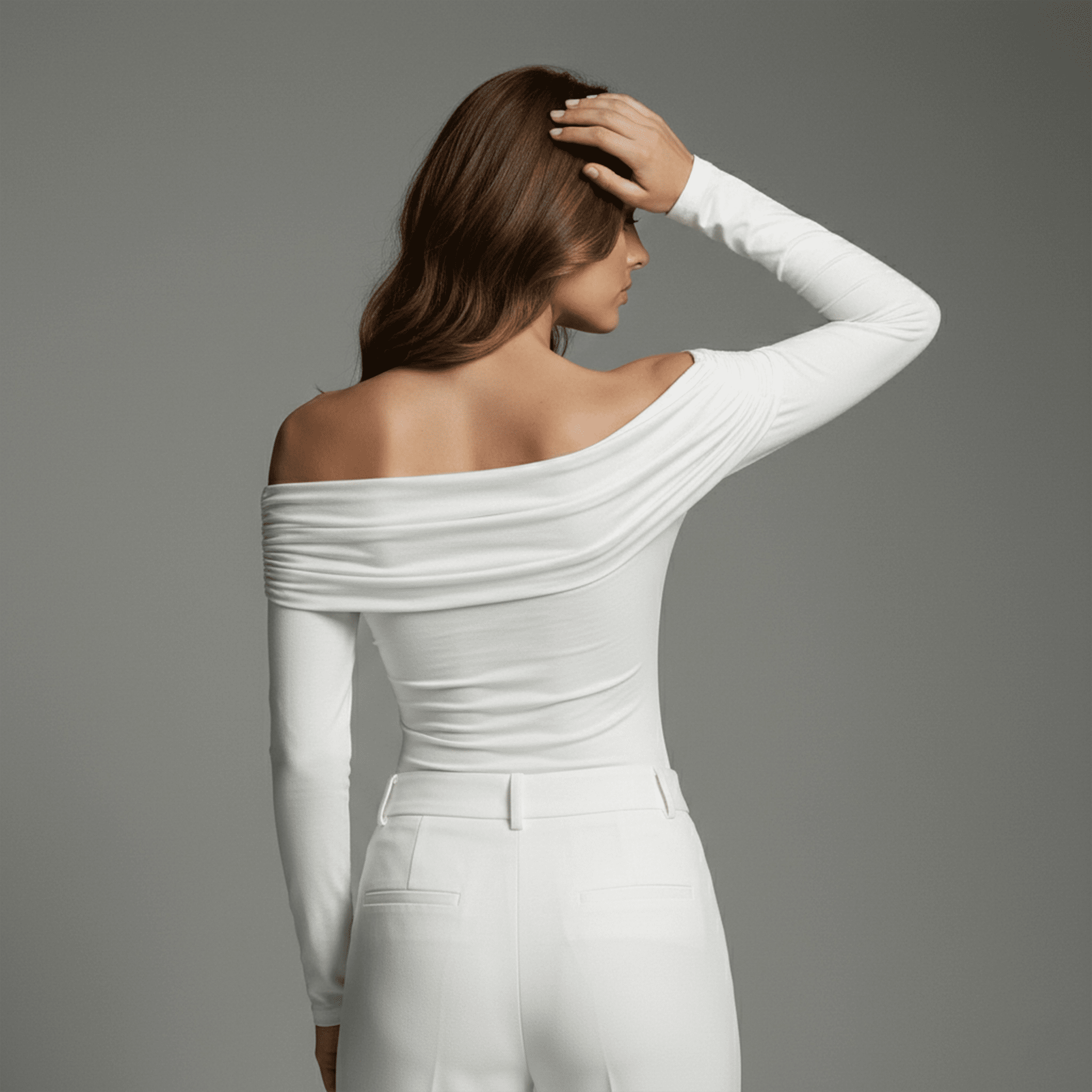 Woman wearing a white off-shoulder top and pants against a gray background