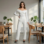 Woman in a white outfit standing in a modern cafe with wooden tables and chairs.