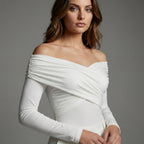 Woman wearing a white off-shoulder dress against a gray background