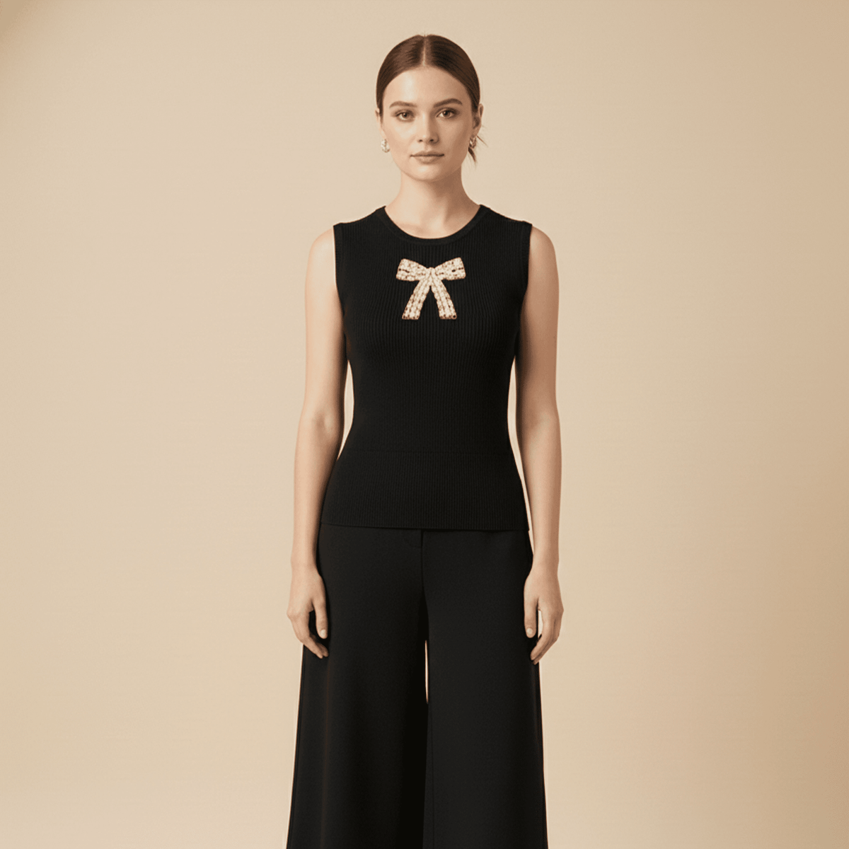 Woman wearing a black sleeveless top with a bow detail on a beige background