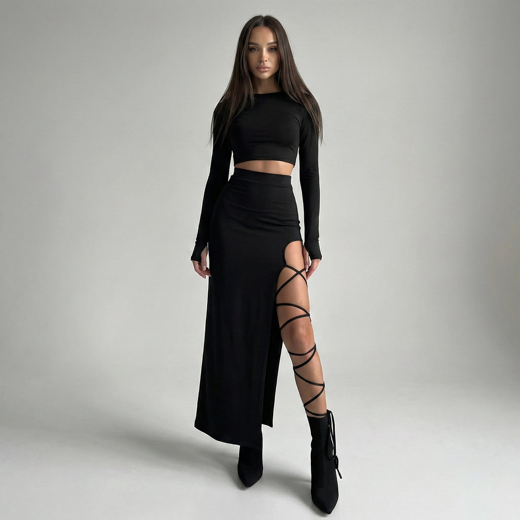 Woman wearing a black outfit with a high slit skirt on a gray background