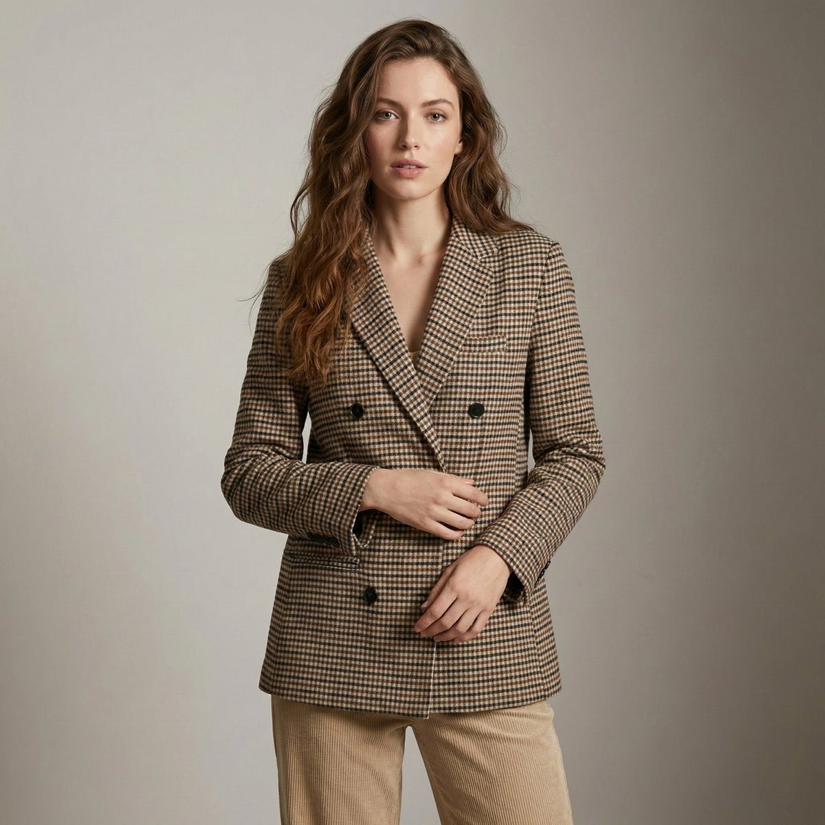 Woman wearing a brown checkered blazer against a plain background