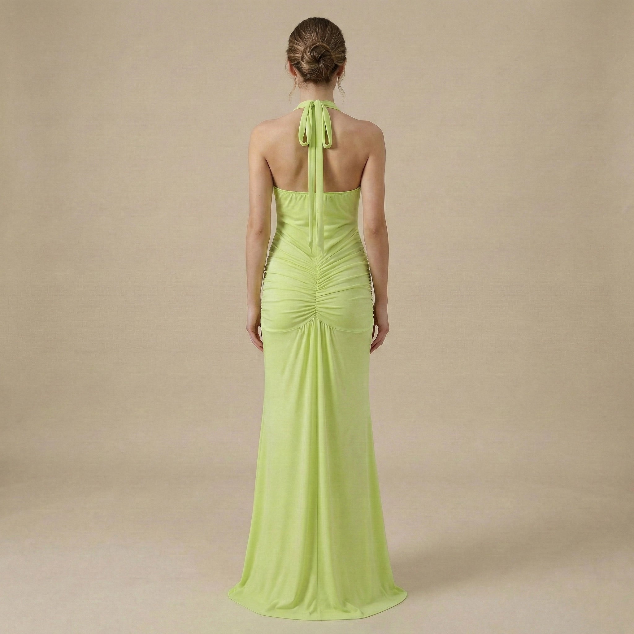 Woman wearing a bright green evening gown on a beige background