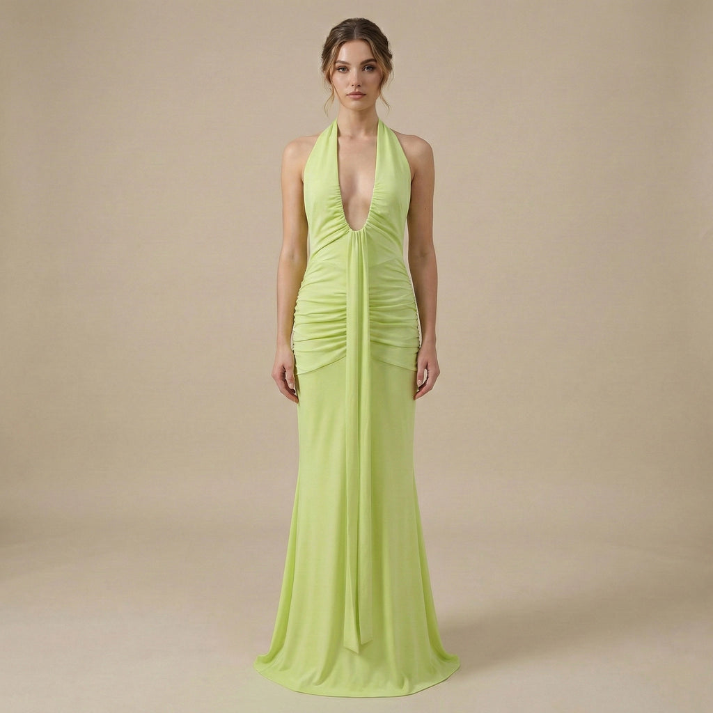 Woman wearing a bright green evening gown against a beige background