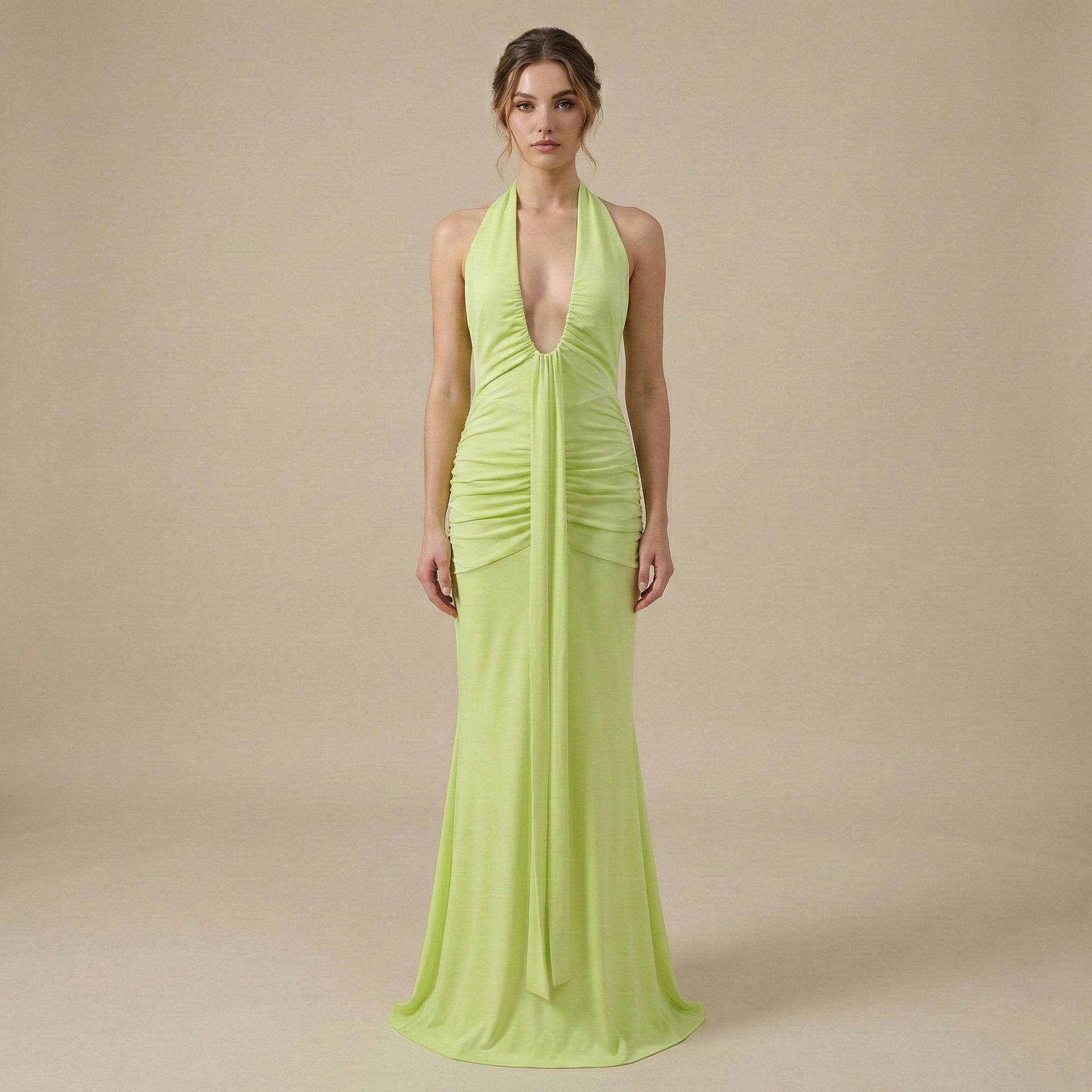 Woman wearing a bright green evening gown against a beige background