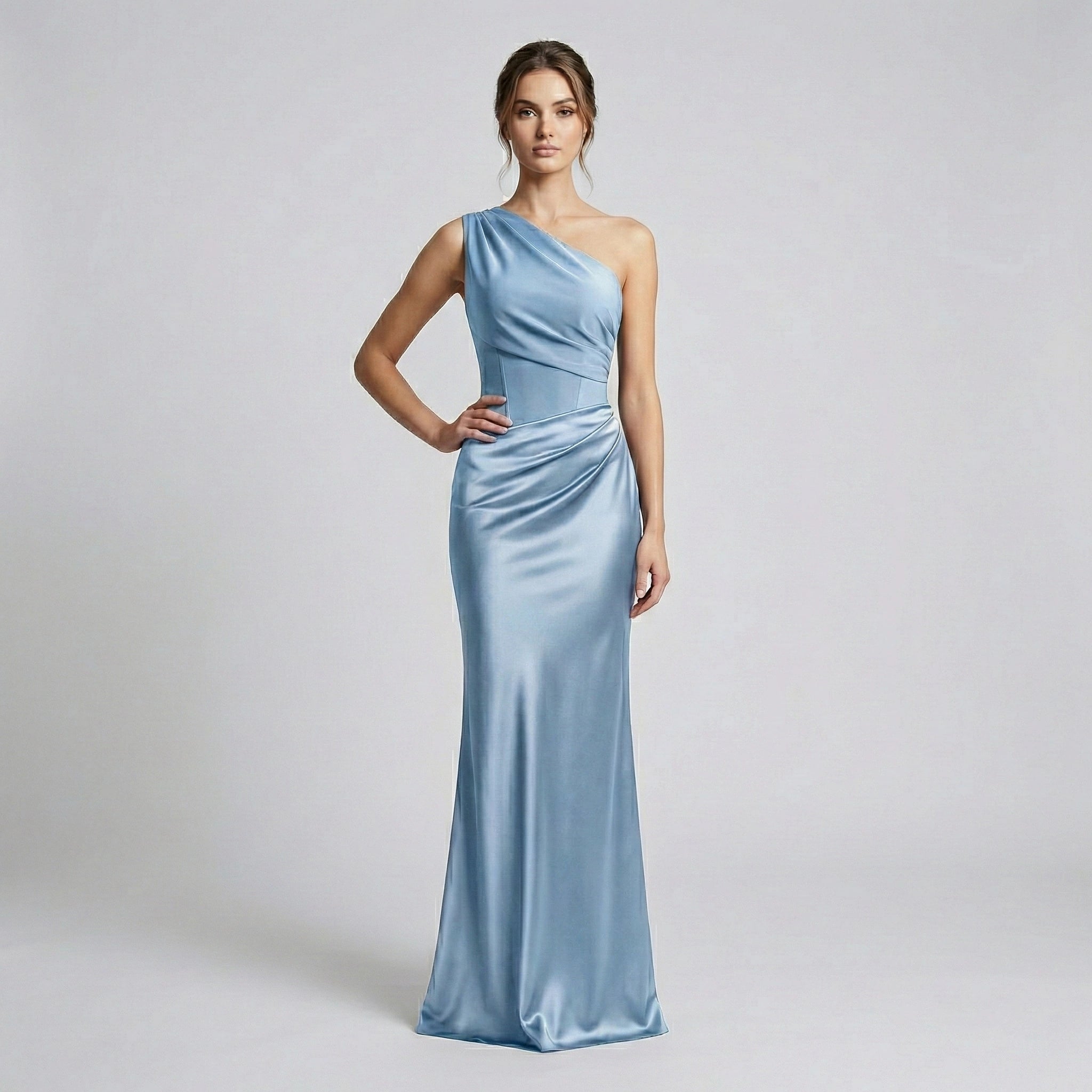 Woman wearing a light blue one-shoulder gown on a plain background