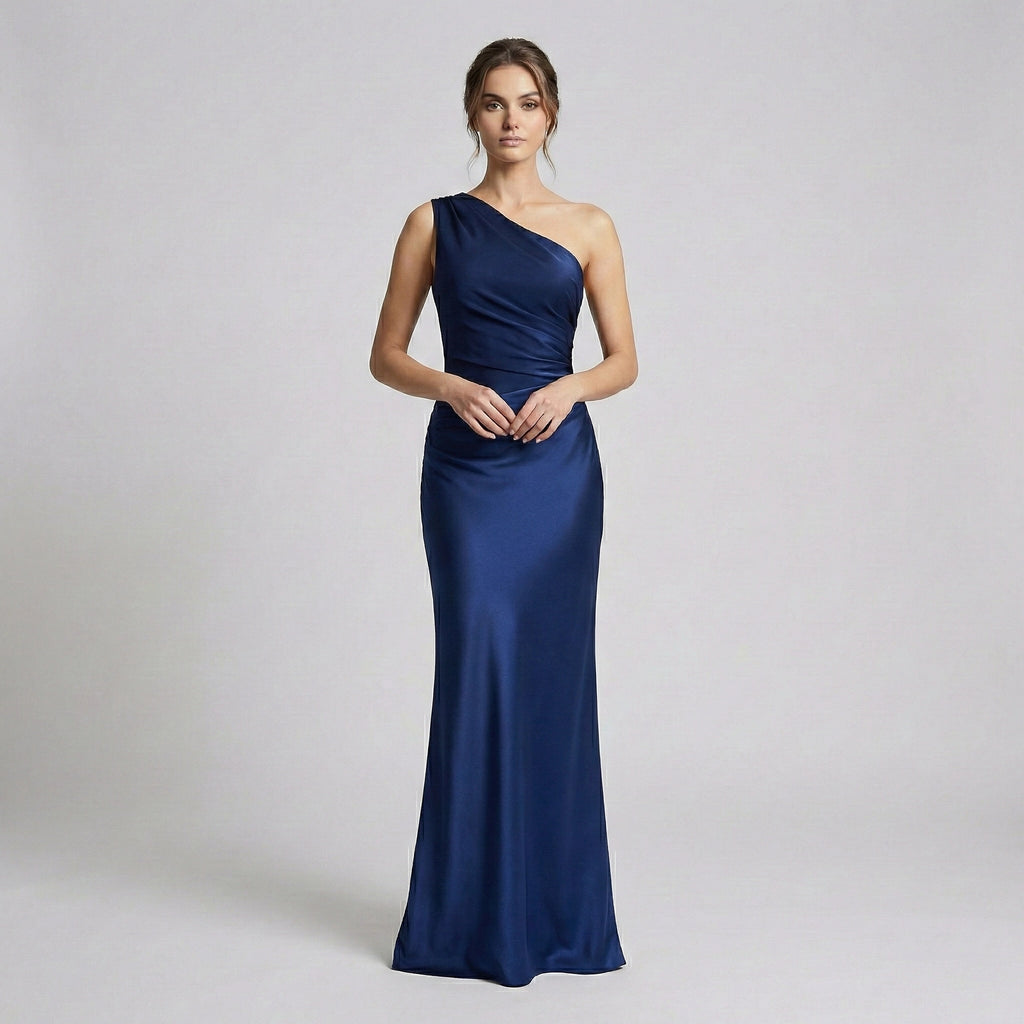 Woman wearing a one-shoulder blue gown on a light gray background