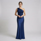 Woman wearing a one-shoulder blue gown on a light gray background