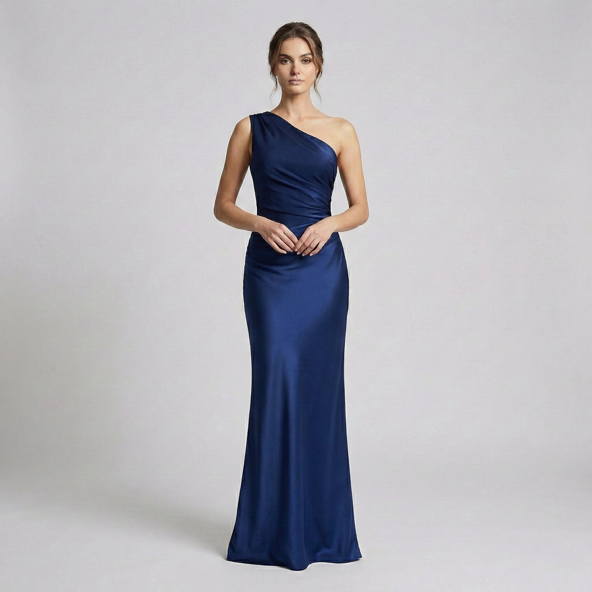 Woman wearing a one-shoulder blue gown on a light gray background