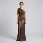 Woman wearing a brown one-shoulder evening gown on a light gray background