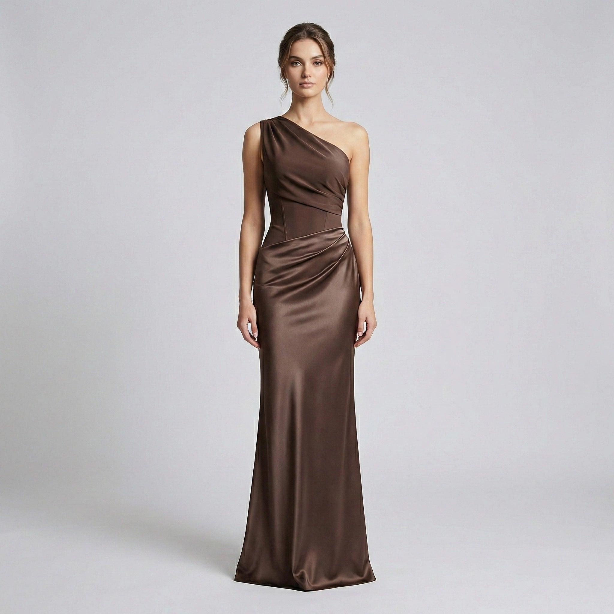 Woman wearing a brown one-shoulder evening gown on a light gray background