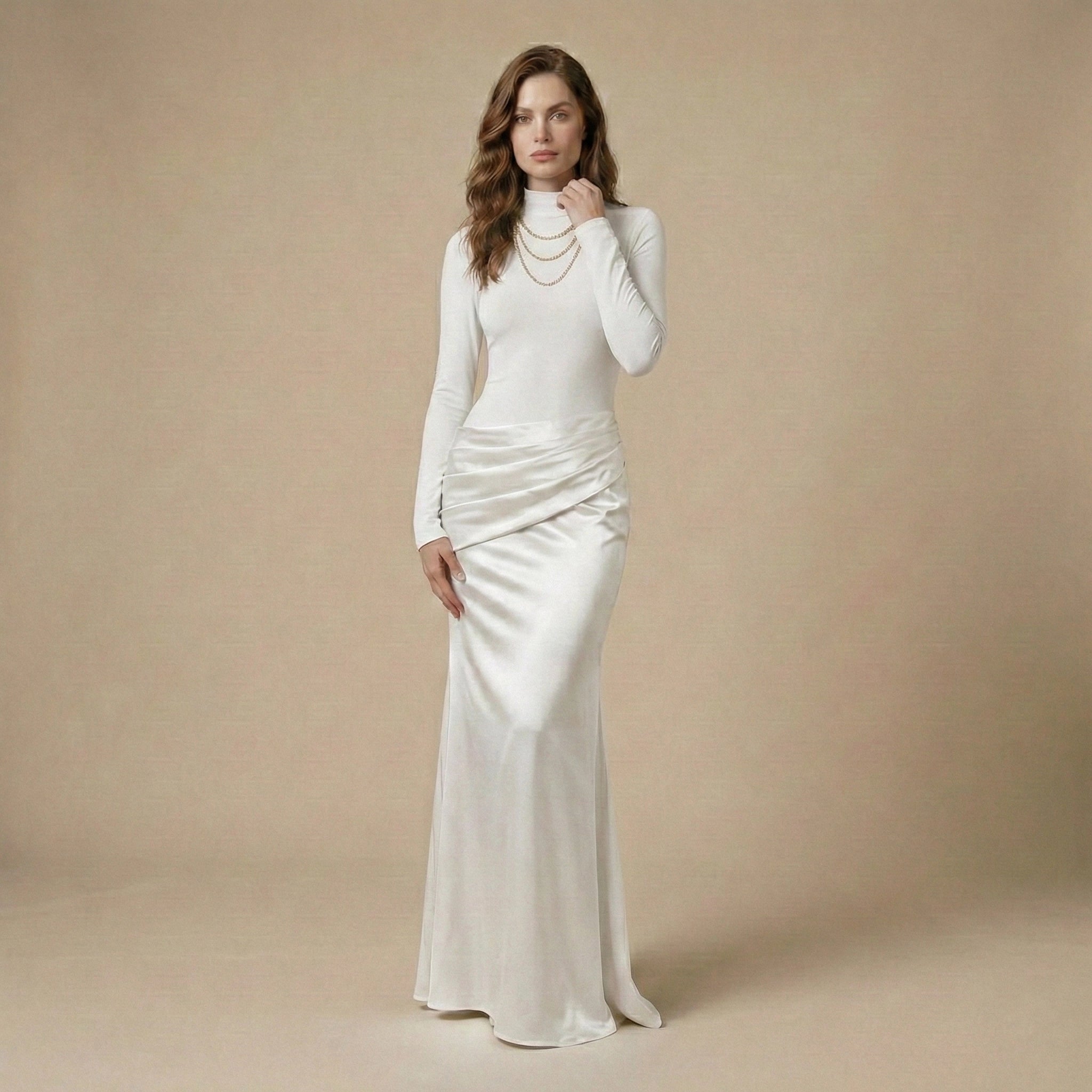 Woman wearing a white long-sleeve gown against a beige background