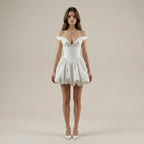 Woman wearing a white off-shoulder dress against a plain background