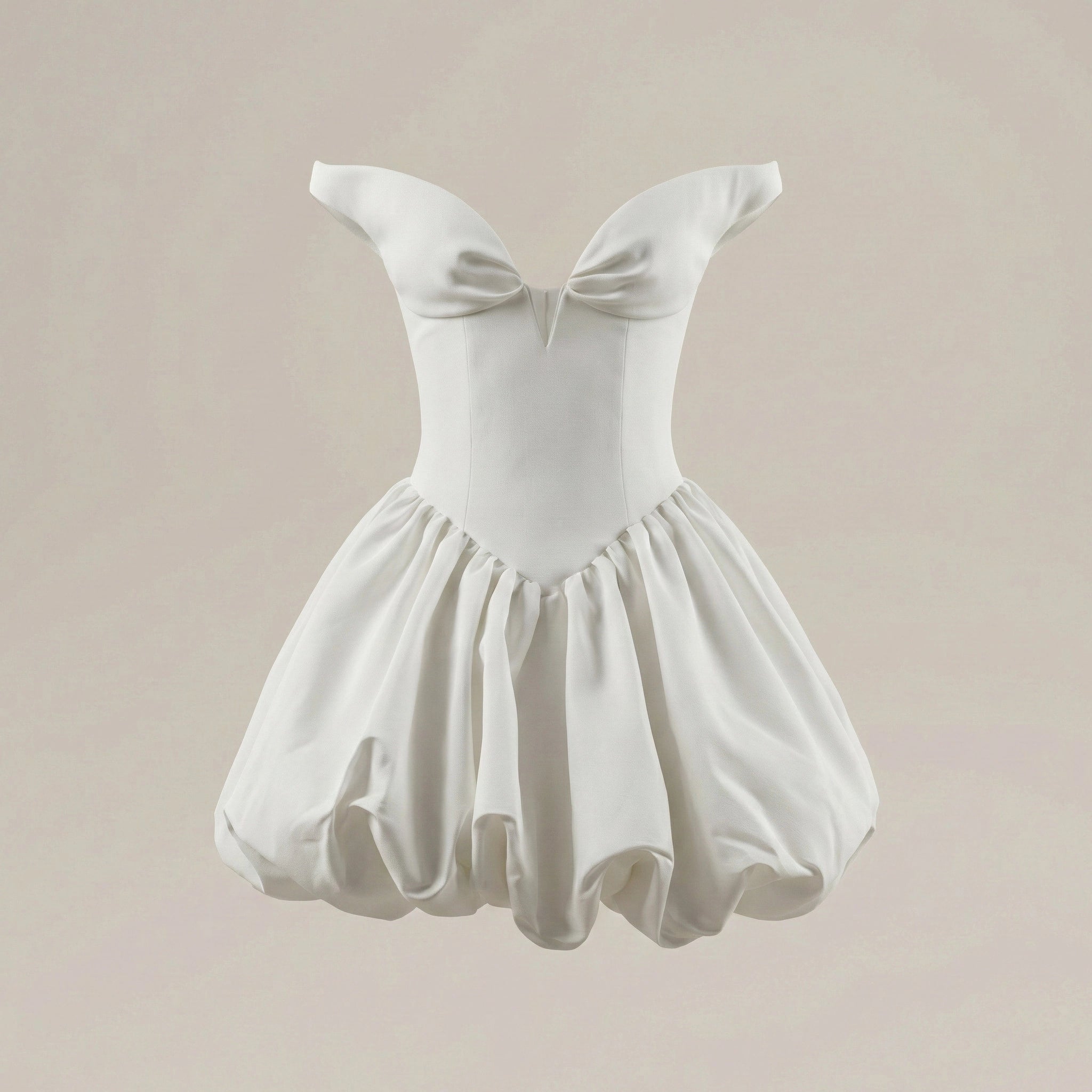 White dress with bow detail on a beige background