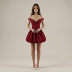 Woman wearing a red off-shoulder dress on a beige background