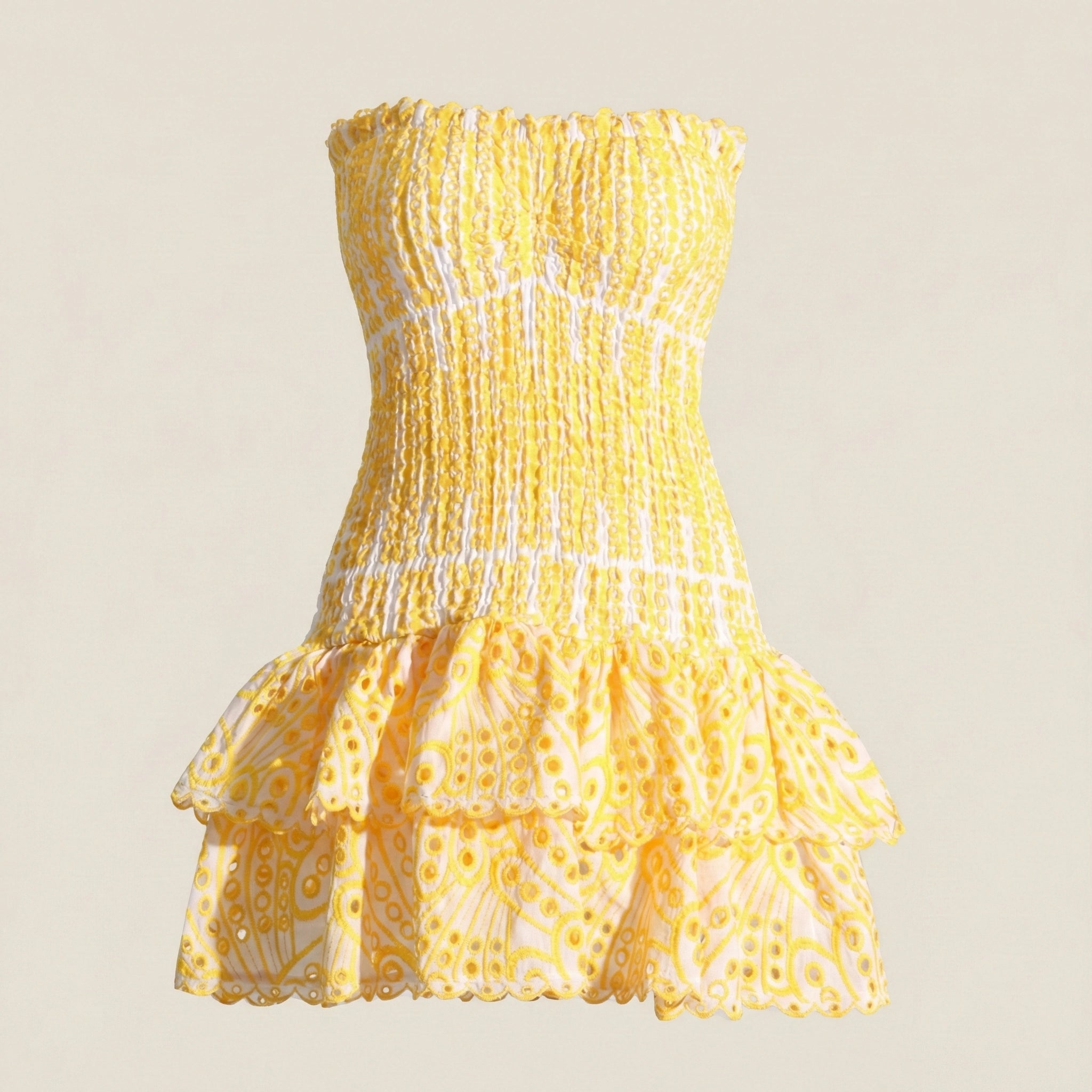 Yellow strapless dress with ruffled layers on a beige background
