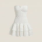 White strapless dress with ruffled hem on a beige background