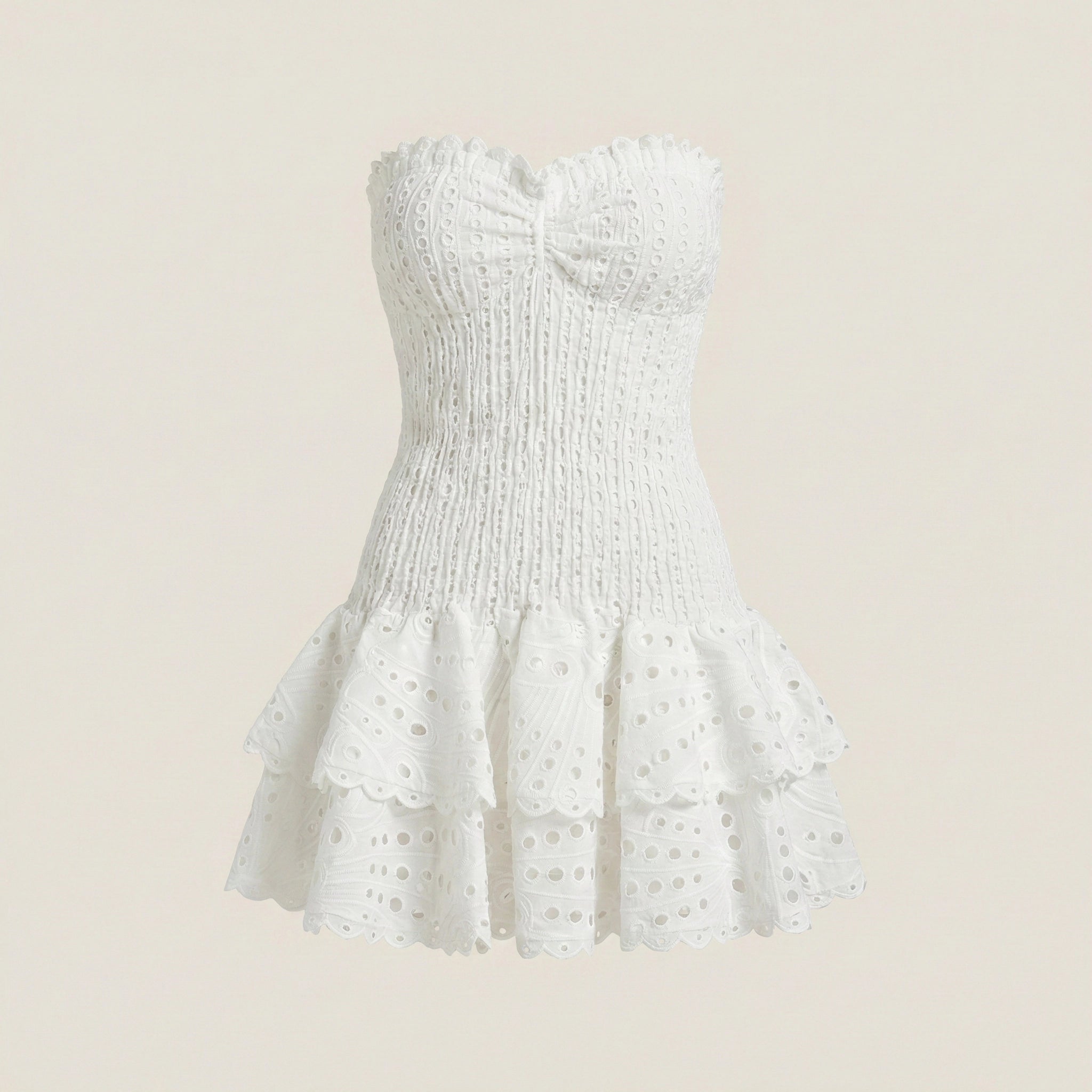 White strapless dress with ruffled hem on a beige background