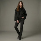 Woman wearing a black outfit against a gray background
