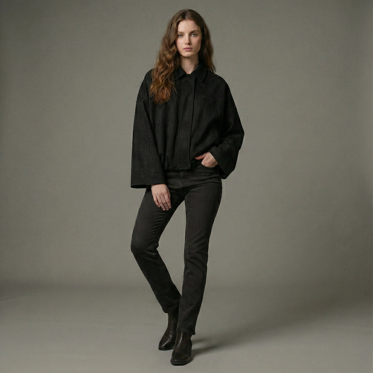 Woman wearing a black outfit against a gray background