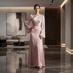 Woman in a pink evening gown standing in a modern interior setting