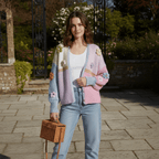 Woman wearing a colorful cardigan with floral patterns in an outdoor setting.
