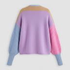 Color-blocked sweater with purple, pink, blue, and beige sections on a light gray background