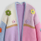 Colorful knitted cardigan with floral decorations on a white background