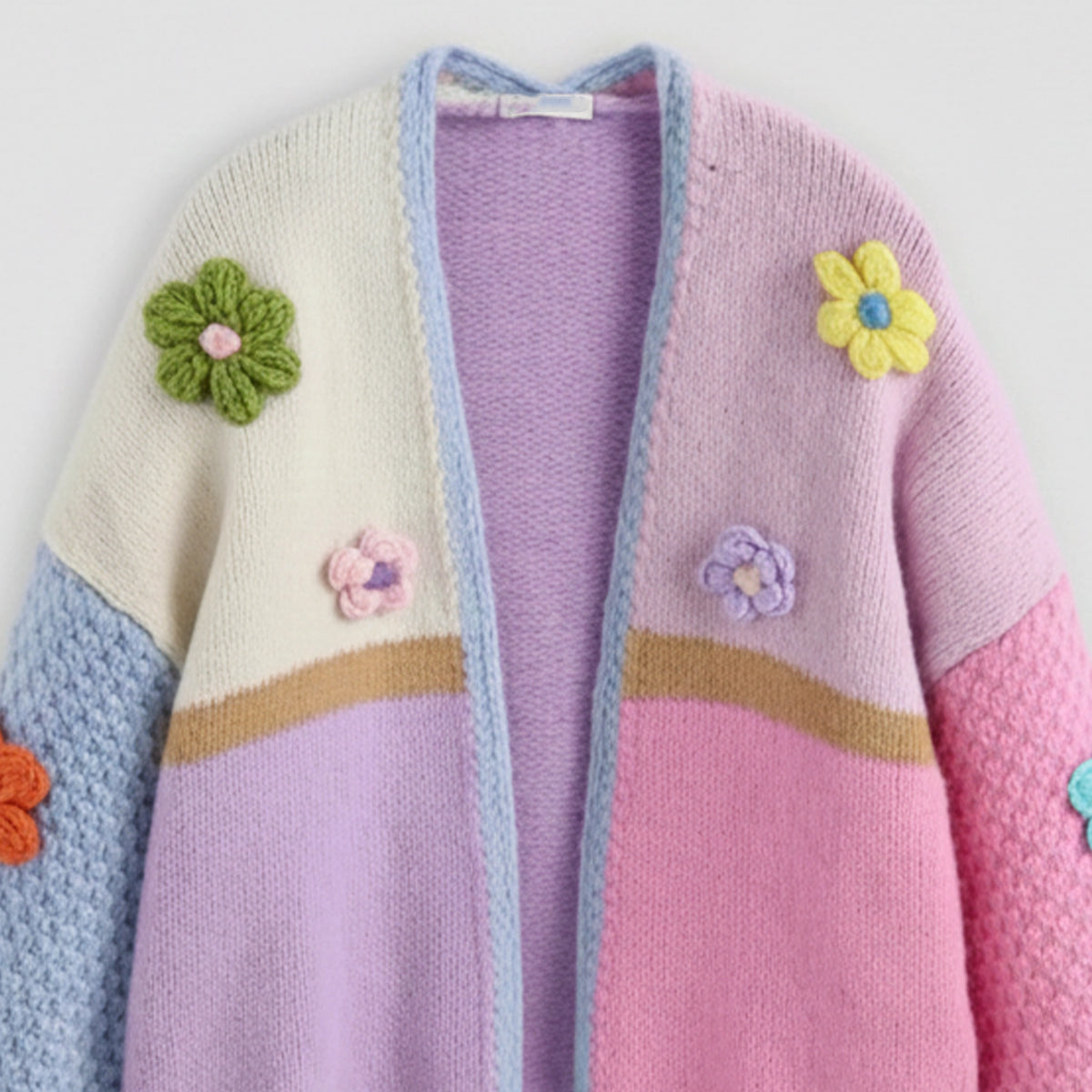 Colorful knitted cardigan with floral decorations on a white background