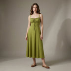 Woman wearing a green dress against a plain background