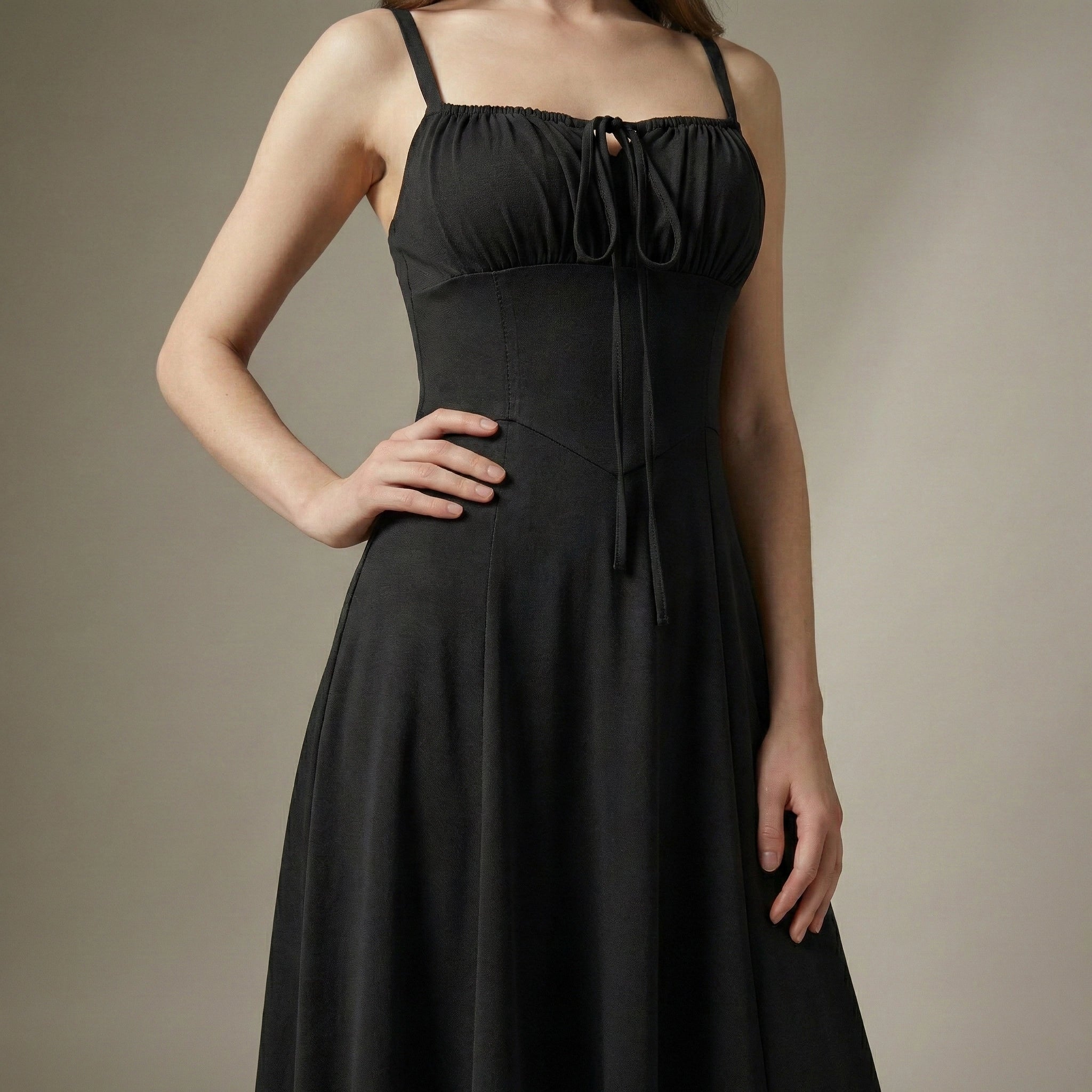 Black dress worn by a model against a neutral background