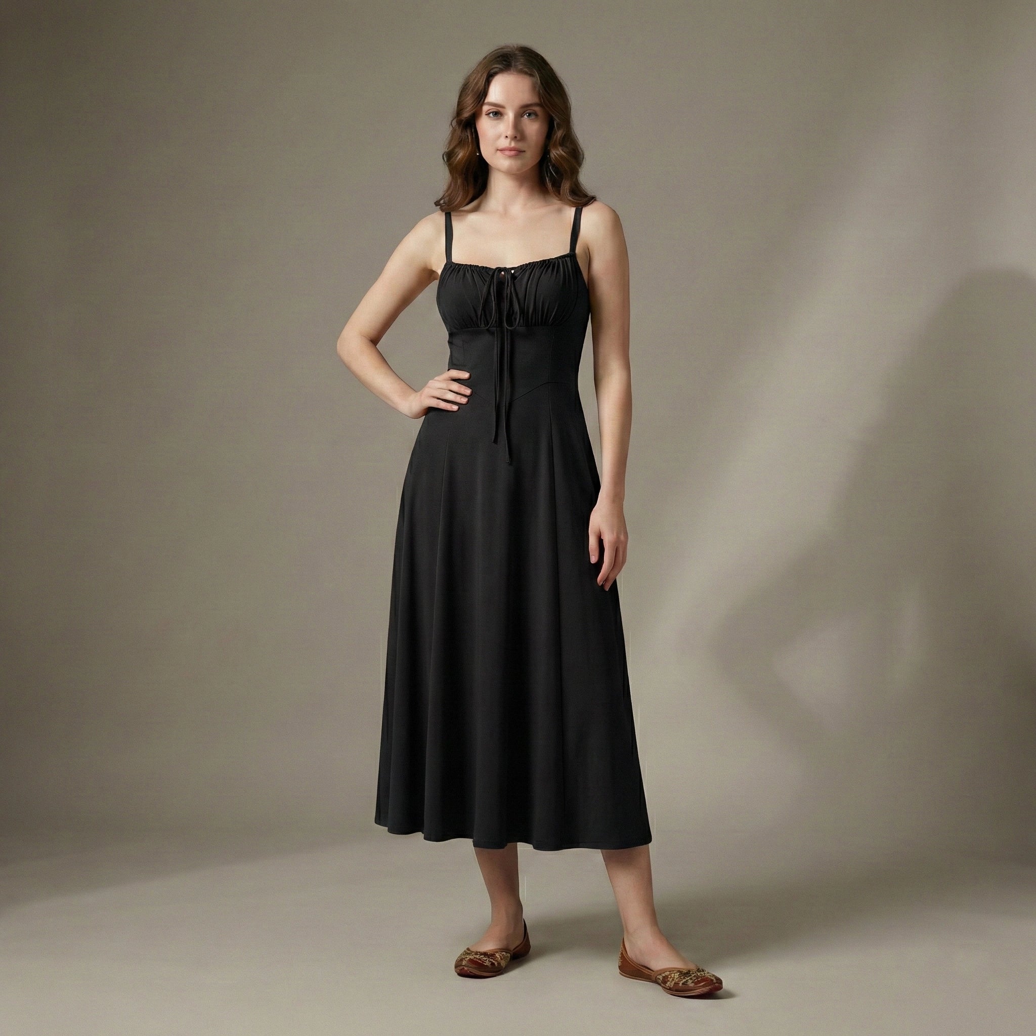 Woman wearing a black dress against a neutral background