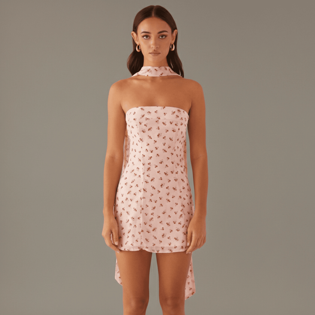 Woman wearing a pink floral dress against a plain background