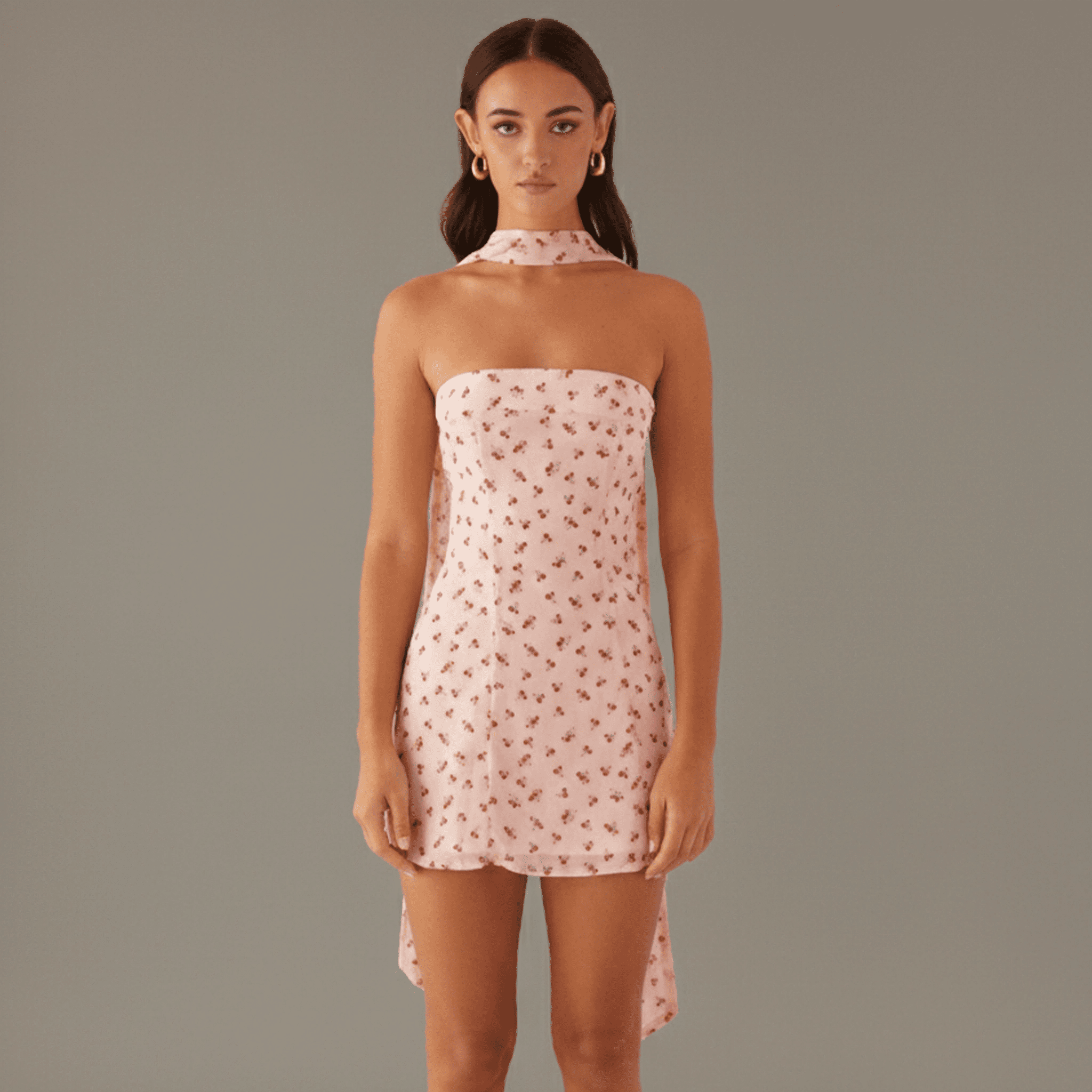 Woman wearing a pink floral dress against a plain background