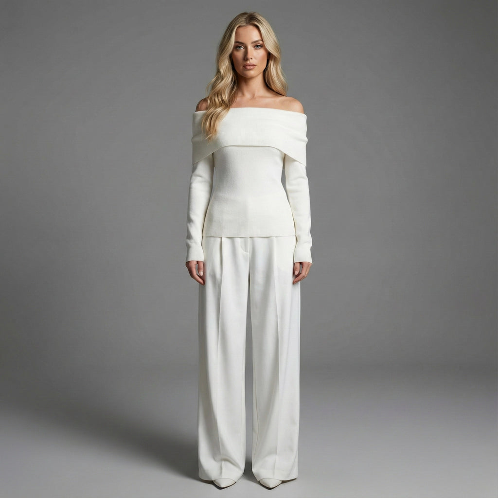 Woman wearing a white off-shoulder top and wide-leg pants against a gray background