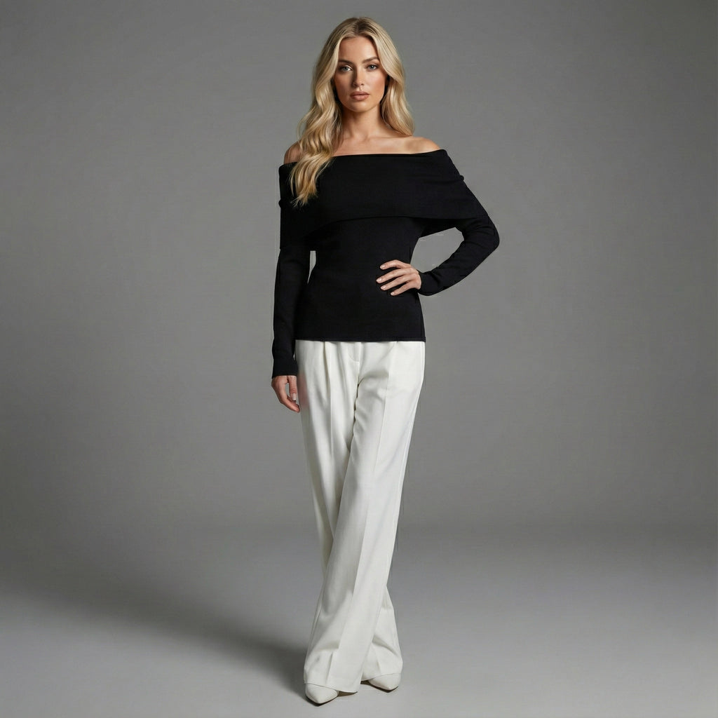 Woman wearing a black off-shoulder top and white pants on a gray background