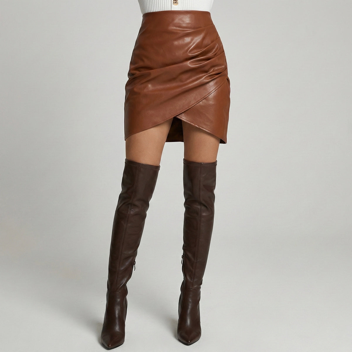 Brown leather skirt and knee-high boots on a plain background