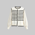 White cardigan with black striped pattern on a light gray background