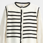 White cardigan with black striped pattern on a white background