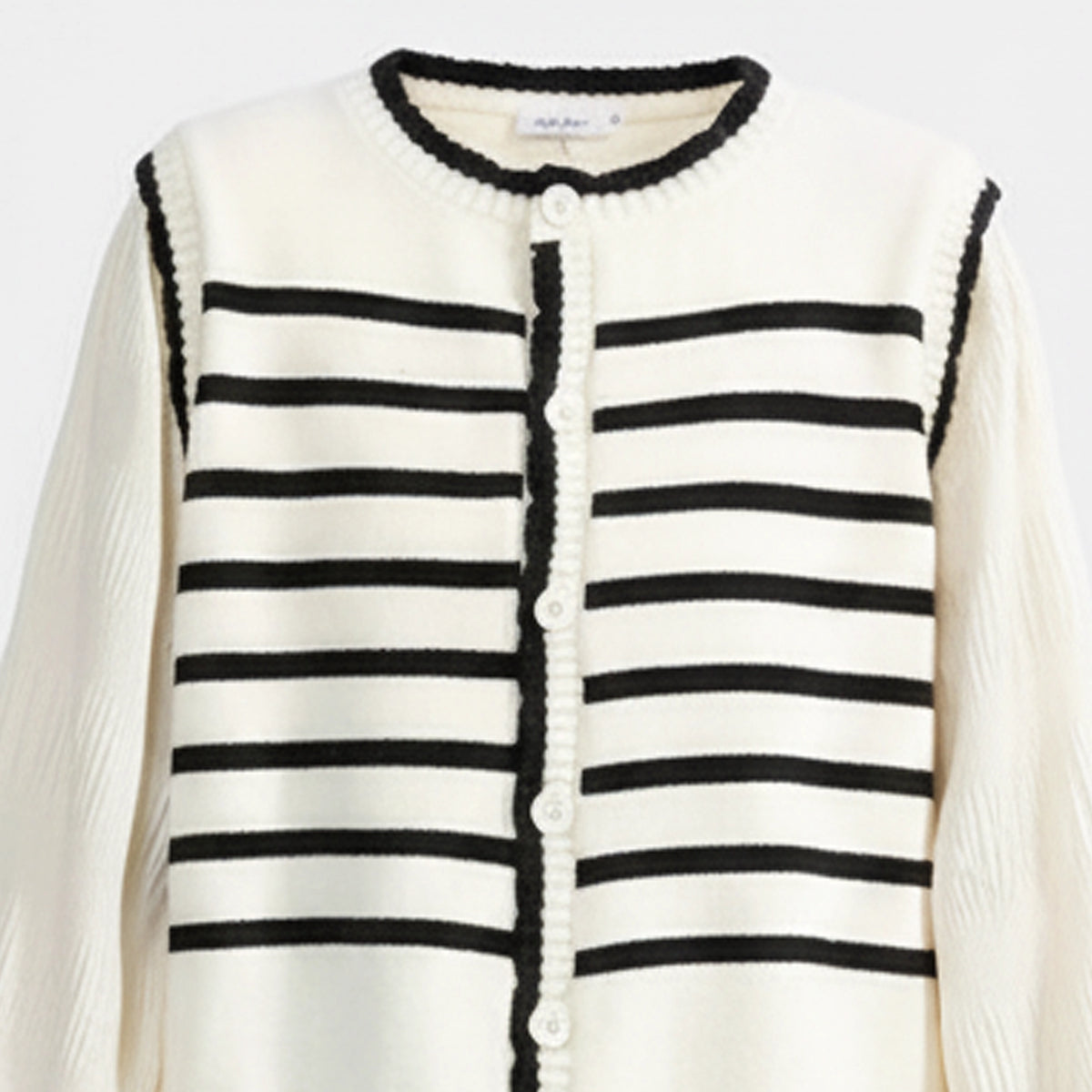 White cardigan with black striped pattern on a white background