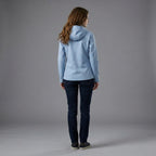 Person wearing a light blue hoodie and dark jeans on a gray background
