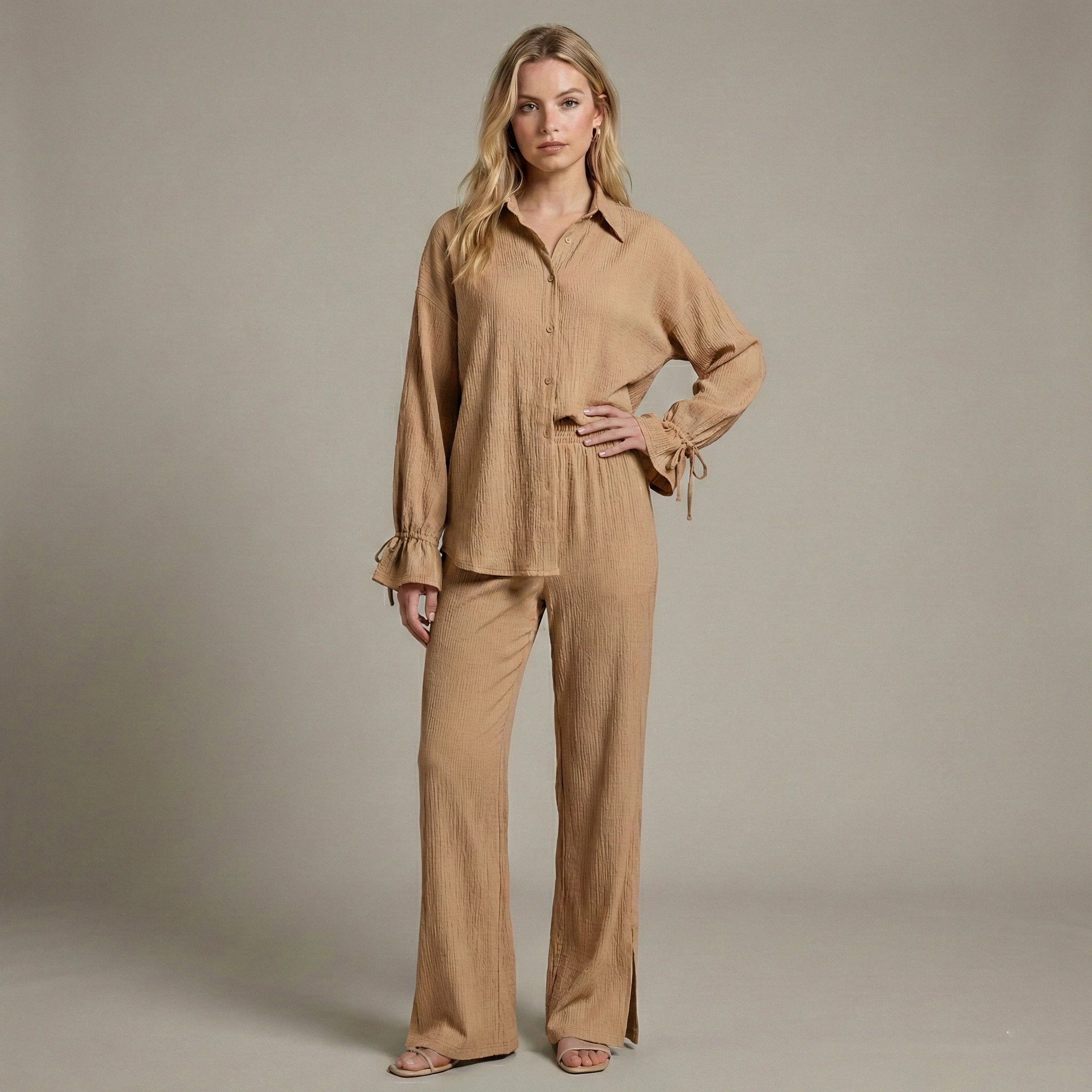 Woman wearing a beige outfit against a plain background