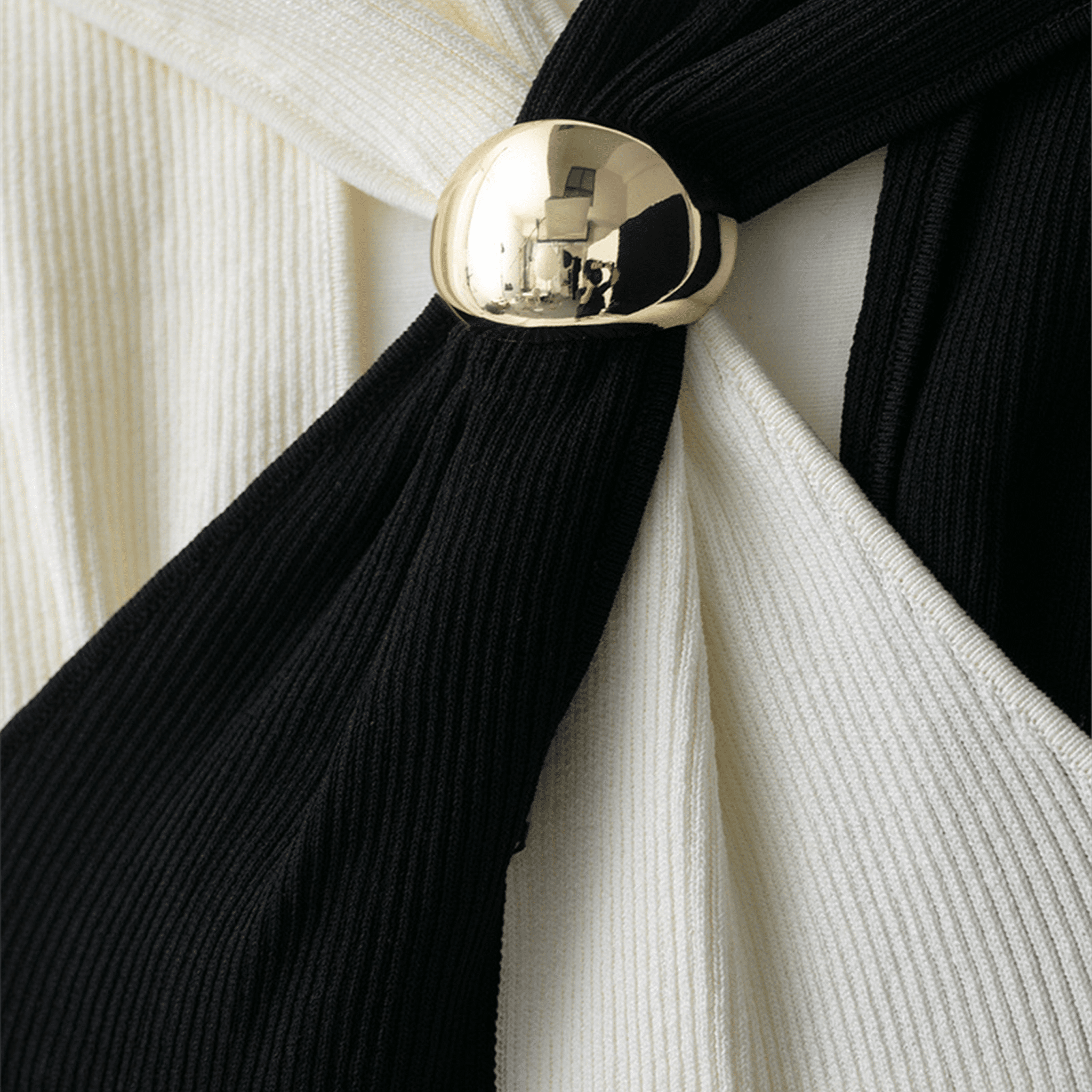 Black scarf with a gold tie knot against a white background