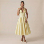 Woman wearing a yellow dress against a plain background