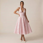 Woman wearing a pink dress against a plain background