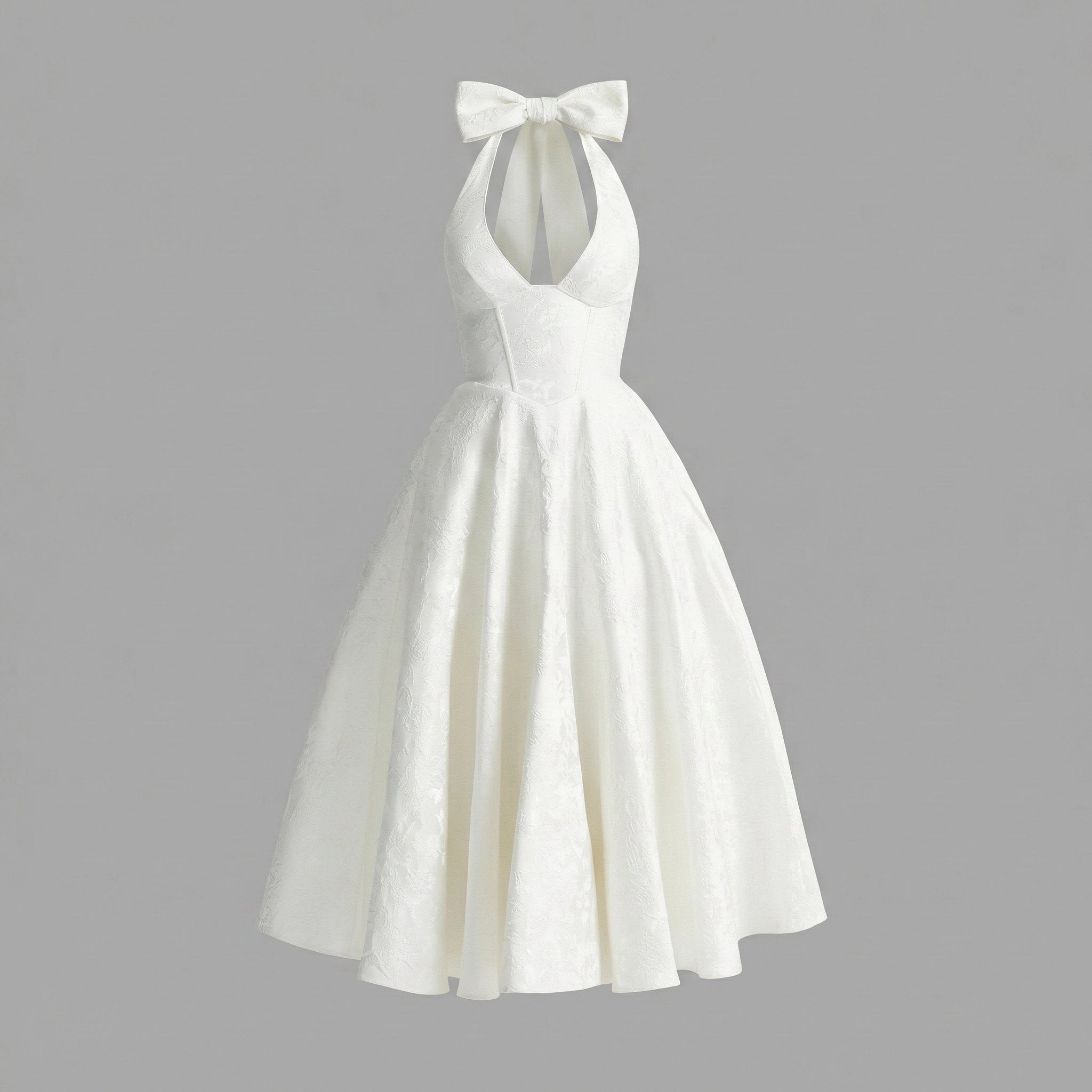 White halter-neck dress with a bow detail on a gray background