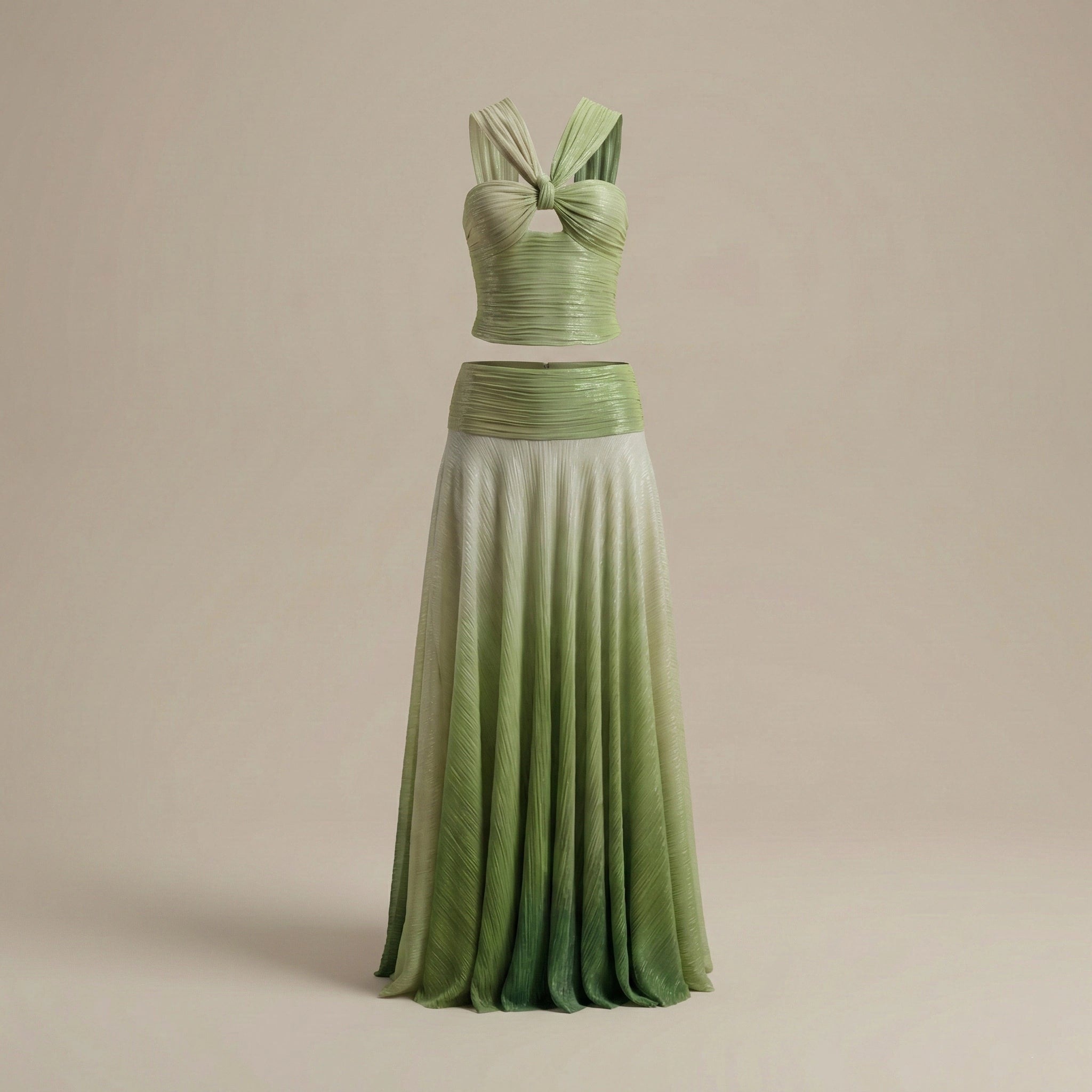 Green two-piece dress with a pleated skirt on a beige background