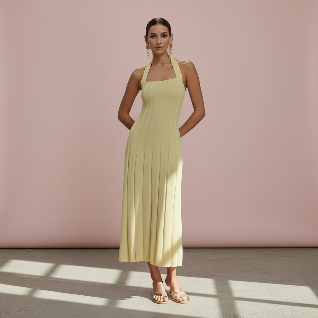 Woman wearing a light yellow dress against a pink wall