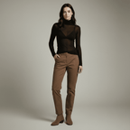 Woman wearing a black sheer top and brown pants against a neutral background